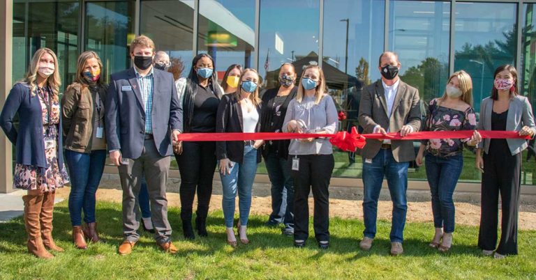 photo of honor credit union ceo scott mcfarland and other honor team members and community members posing with a ribbon at the kalamazoo stadium drive member center ribbon cutting ceremony