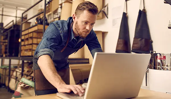 business owner looking at a laptop in his workshop