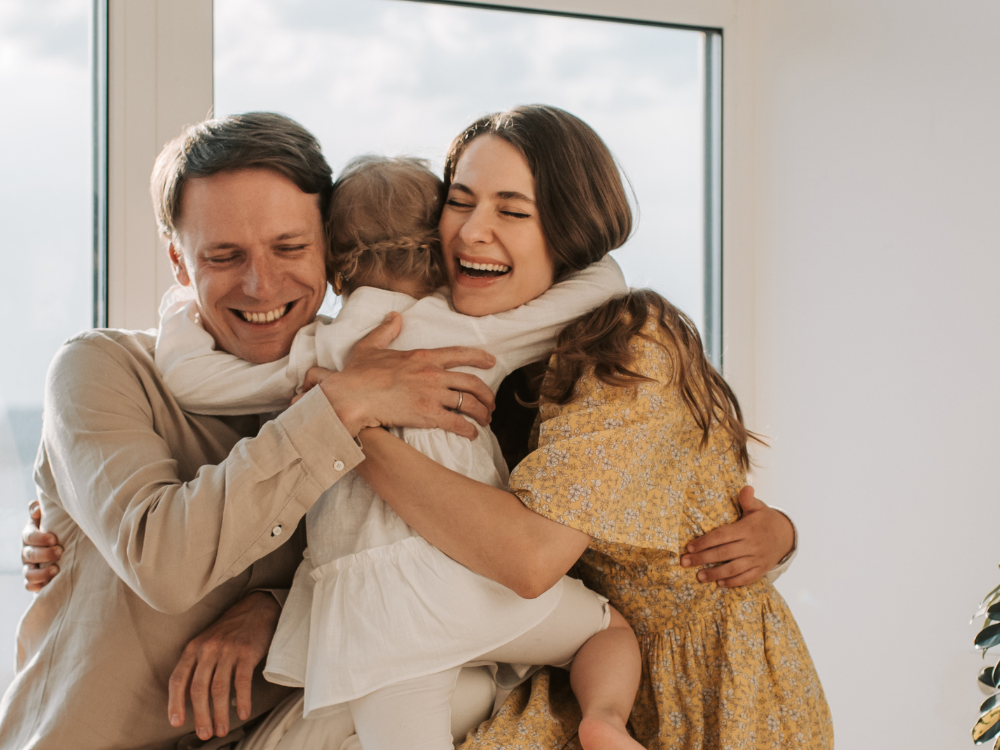 mother and father hugging a small child