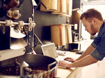 Small business owner of roastery checking his laptop